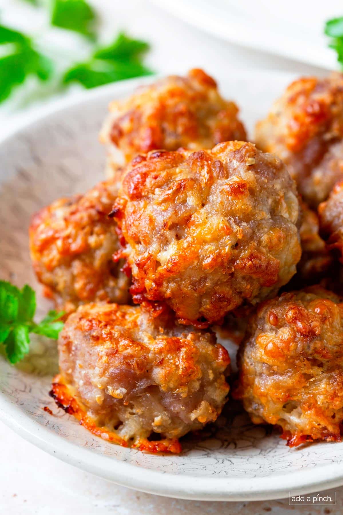 Photo of cooked sausage balls in a white serving bowl.