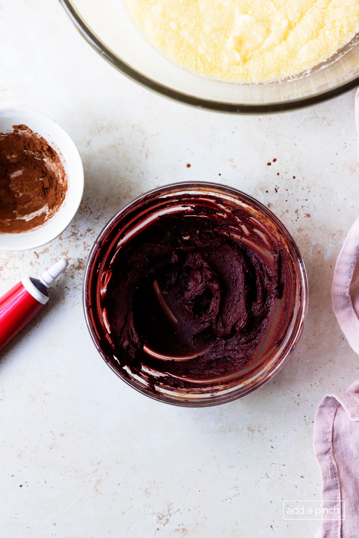 Photo of cocoa powder and red food coloring combined for red velvet cake recipe.