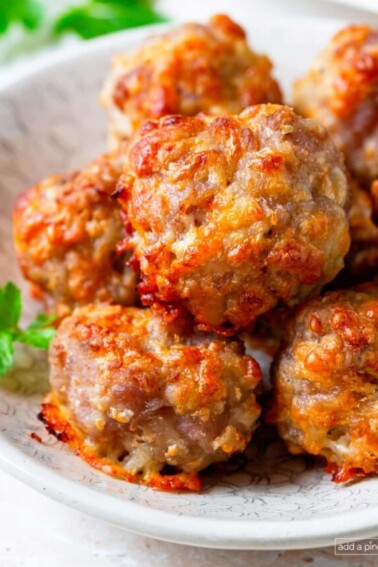 Photo of cooked sausage balls in a white serving bowl.