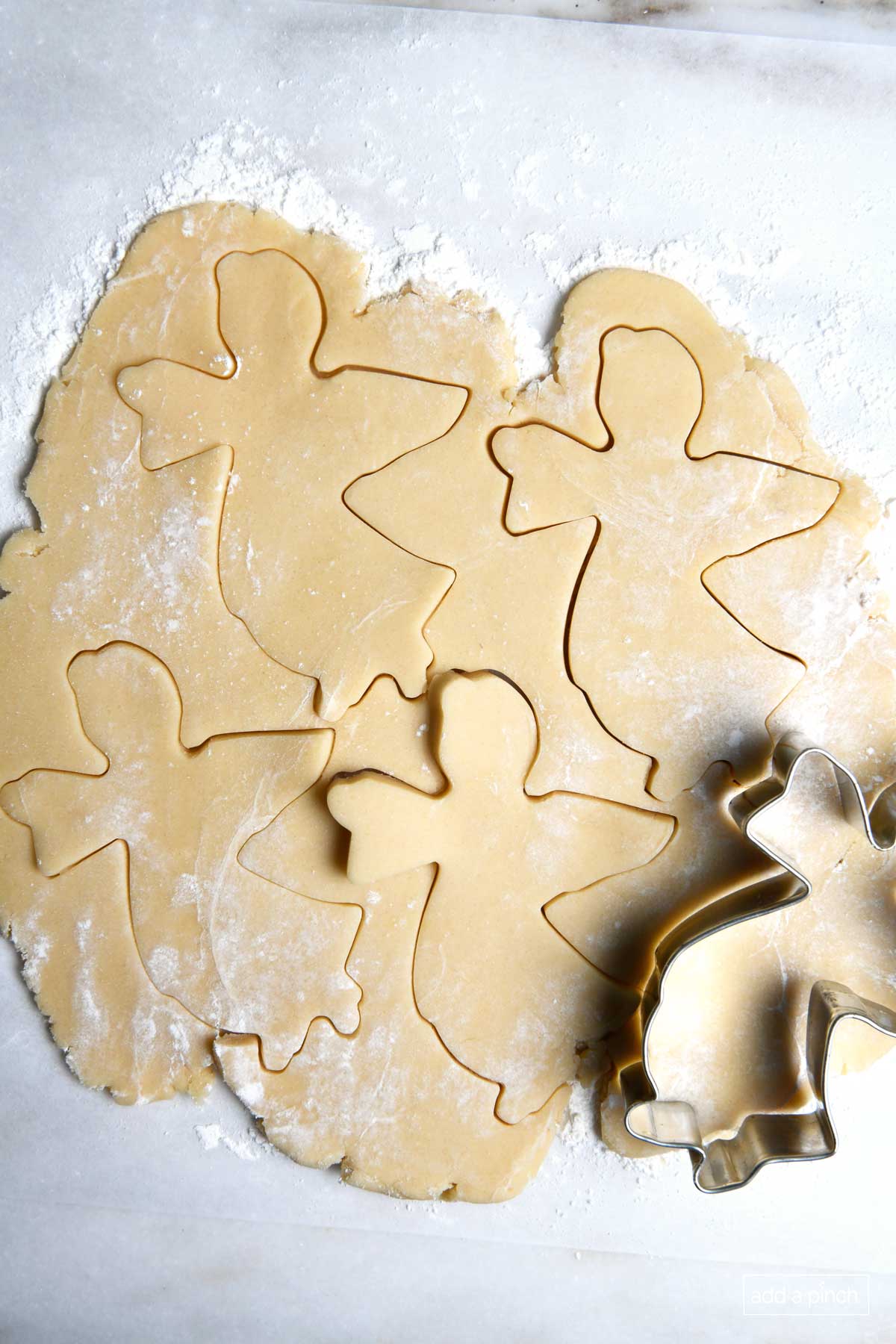 Photo of rolled sugar cookie dough with angel cookie cut-outs.
