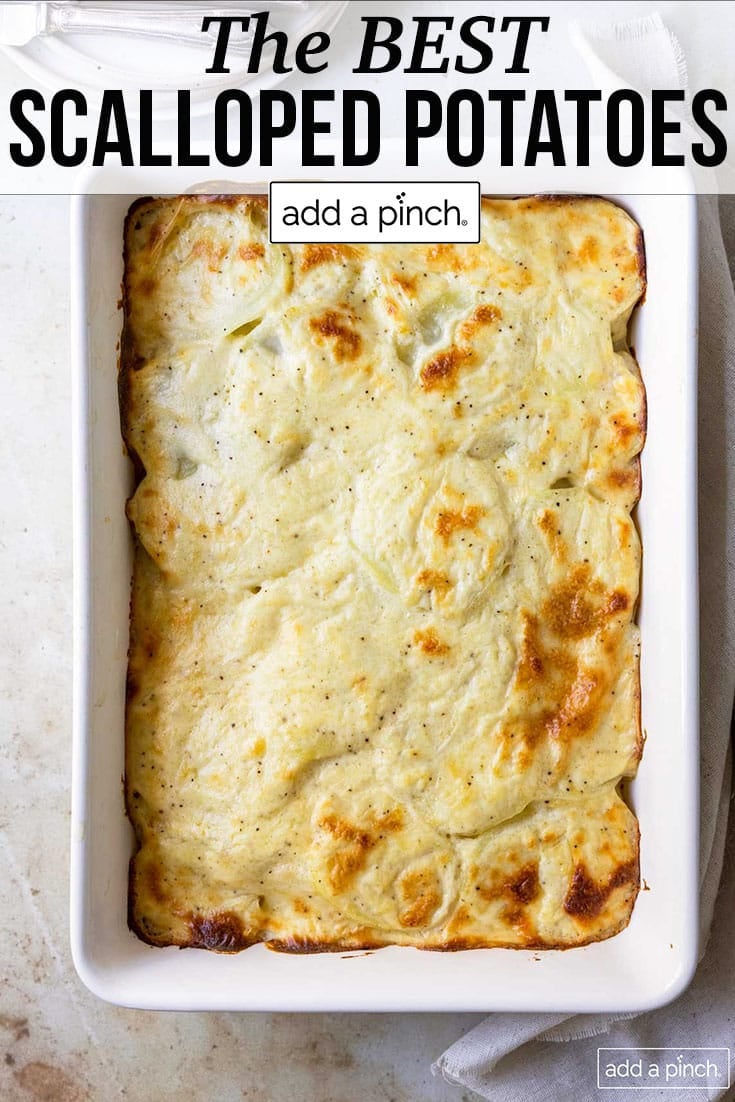 Baking dish with browned scalloped potatoes - with text - addapinch.com