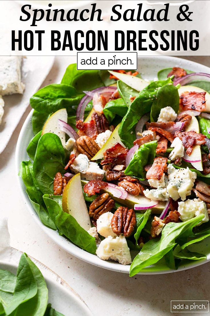 Spinach Salad with pecans, pears, bacon, cheese drizzled with hot bacon dressing - with text - addapinch.com
