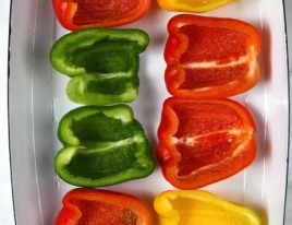 Bell peppers cut lengthwise with the seeds and membrane removed in a baking dish.