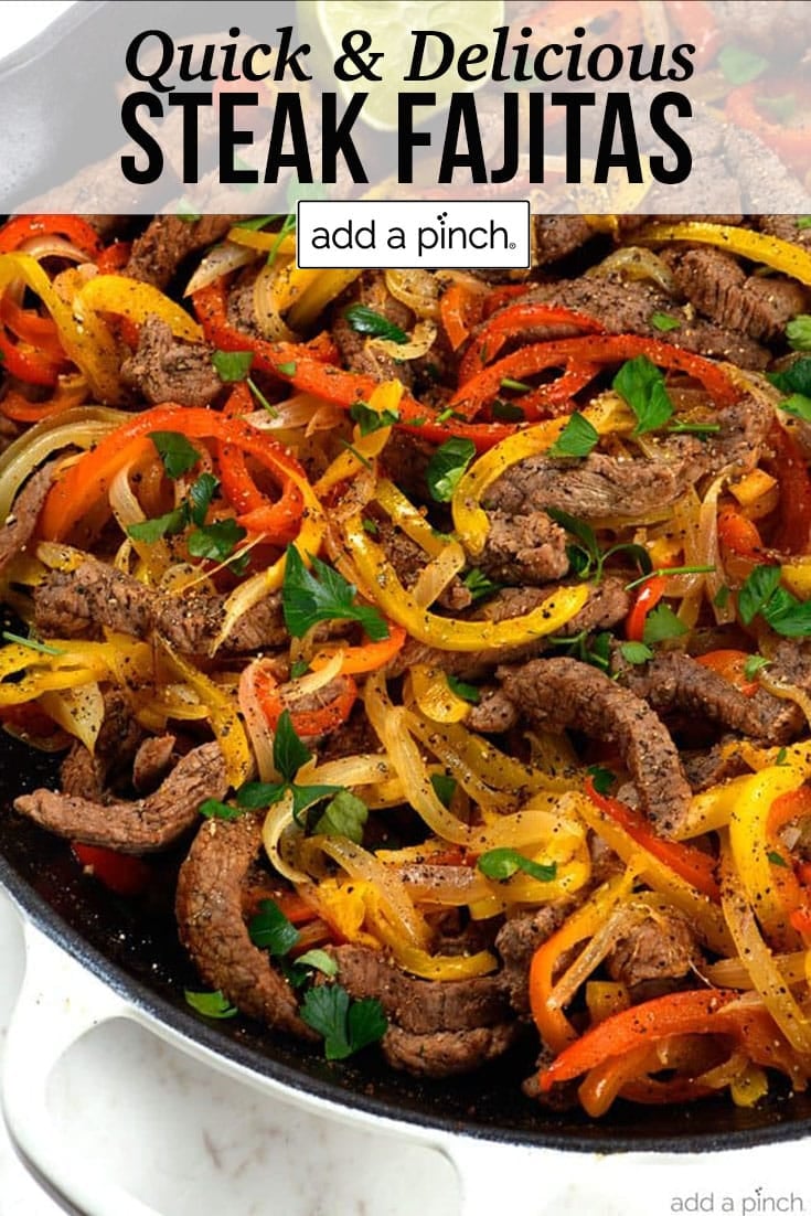 Skillet with steak fajitas with strips of steak and peppers with lime on side - with text - addapinch.com