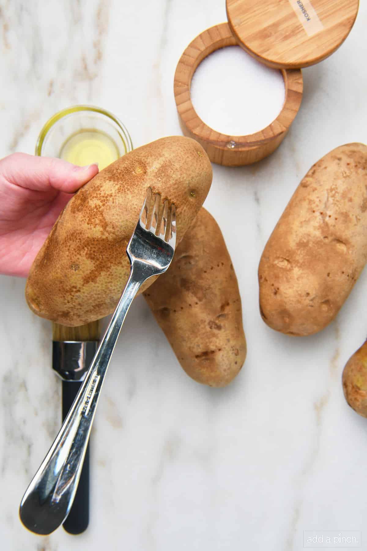 Fork pricking potatoes.