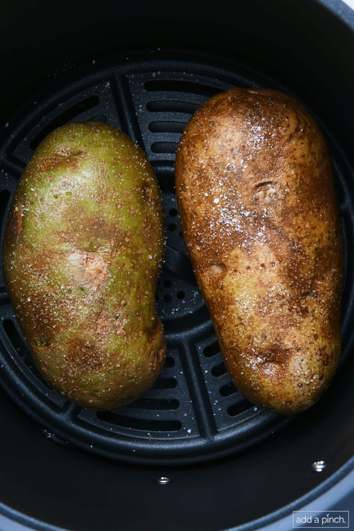 Potatoes arranged in air fryer basket.