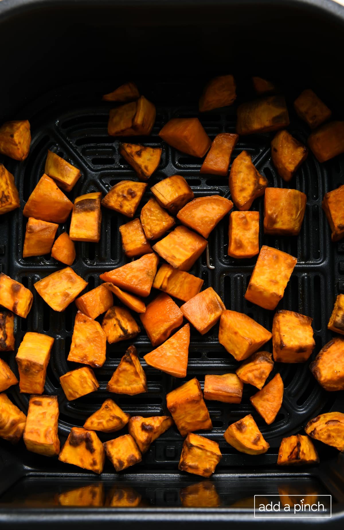 Crispy air fryer sweet potatoes in an air fryer basket. 