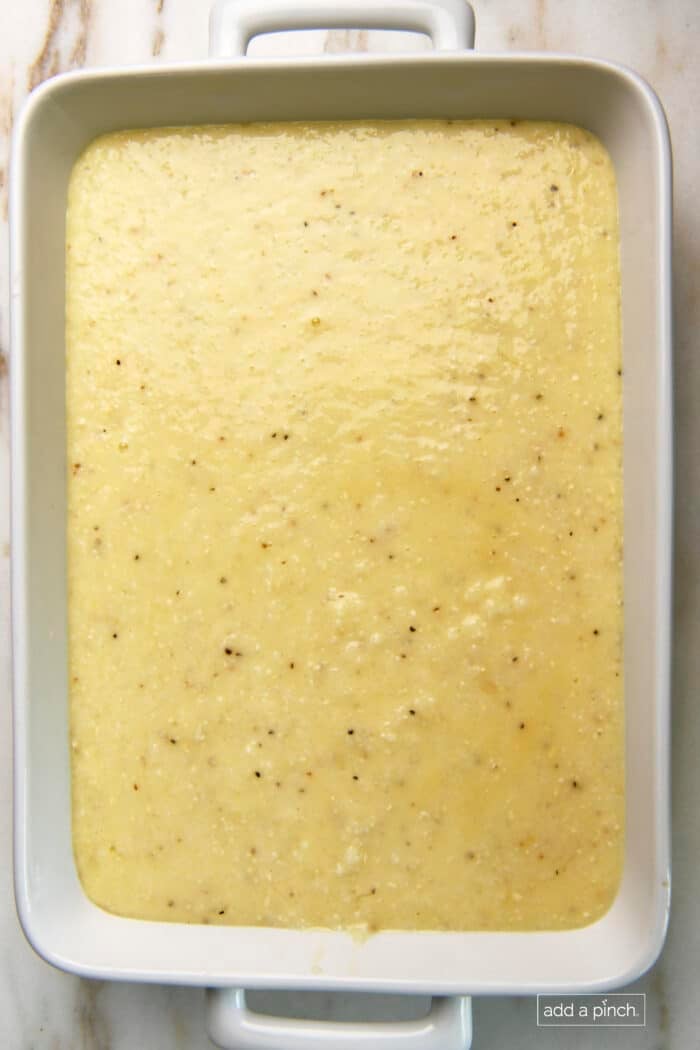 Photo of grits casserole mixture added to a baking dish for cooking.