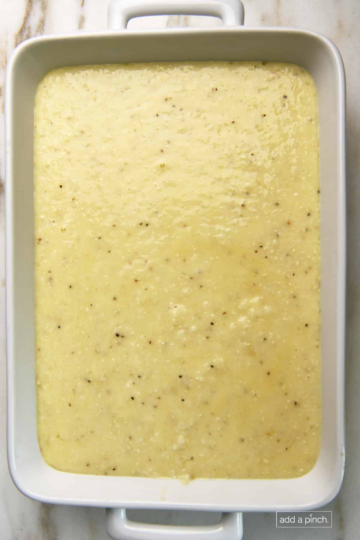 Photo of grits casserole mixture added to a baking dish for cooking.