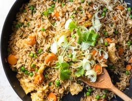 Photo of fried rice in a skillet with green onions and cilantro.