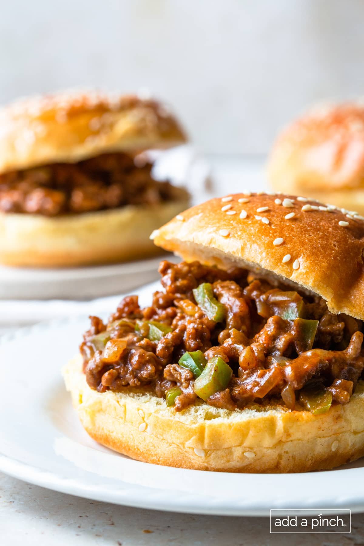 Photo of sloppy joes on a white plate with a second in the background.
