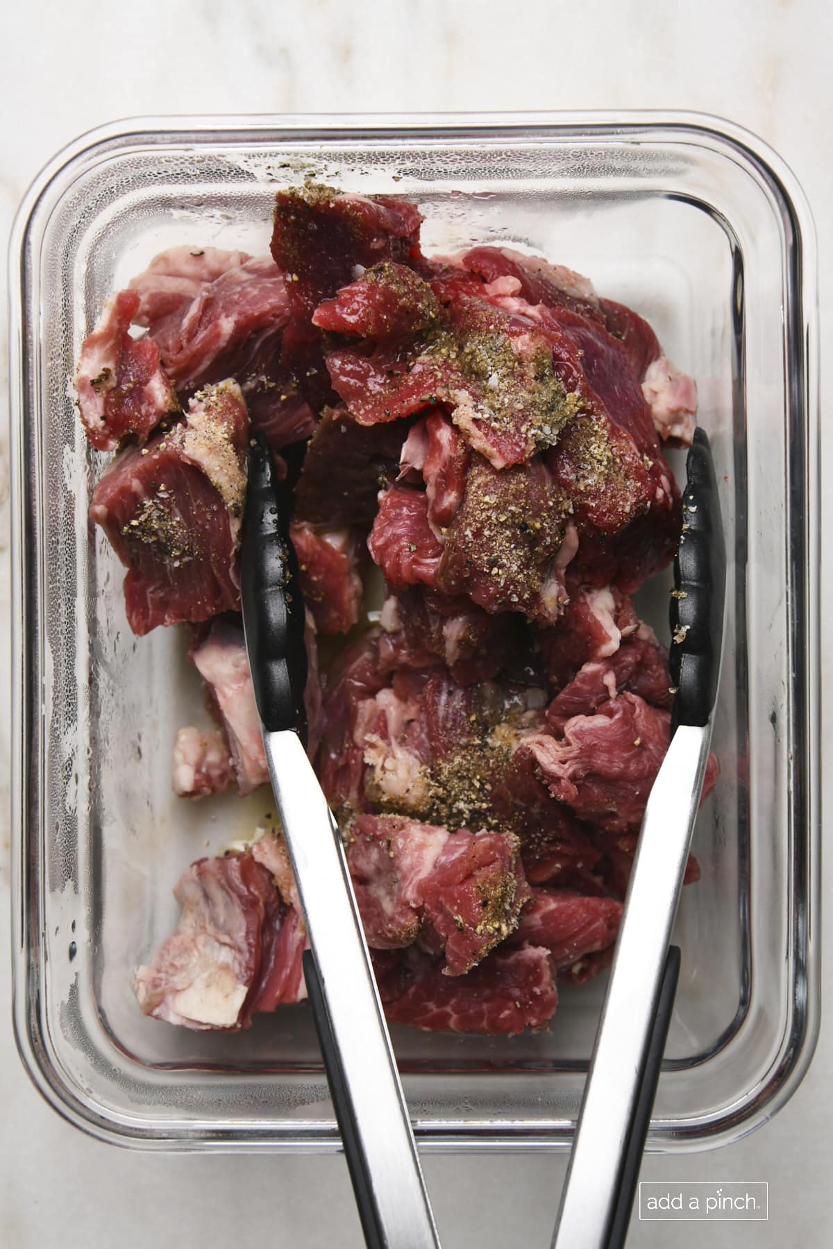 Photo of steak bites with seasonings ready to marinate.