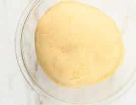 Risen dough in a glass bowl.