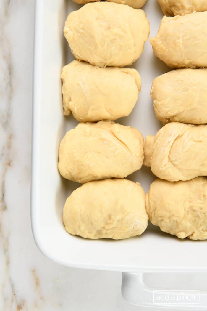 Formed rolls in a baking dish ready to rise and be baked.