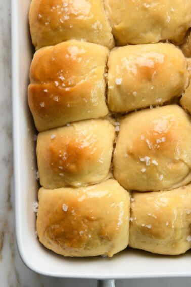 Baked dinner rolls brushed with butter and sprinkled with salt.