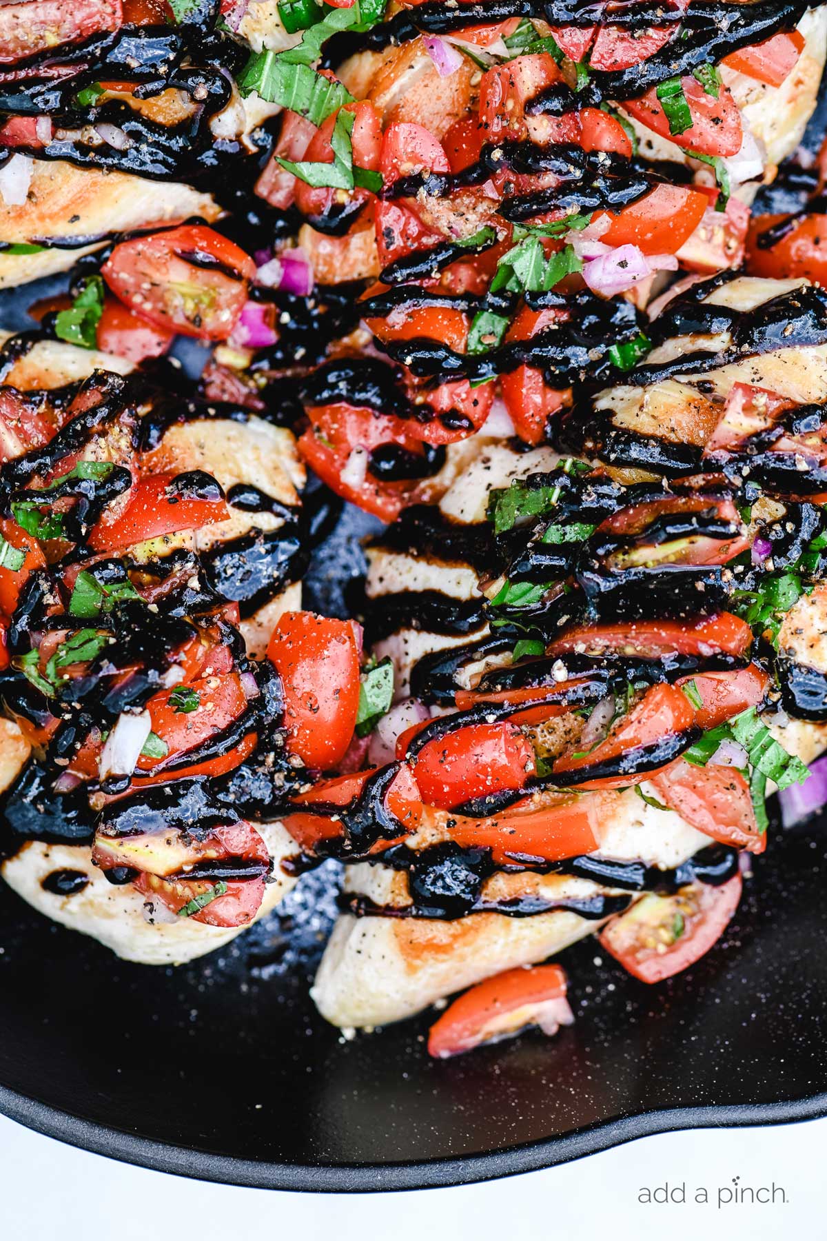 Overhead photograph of bruschetta topped chicken in skillet.