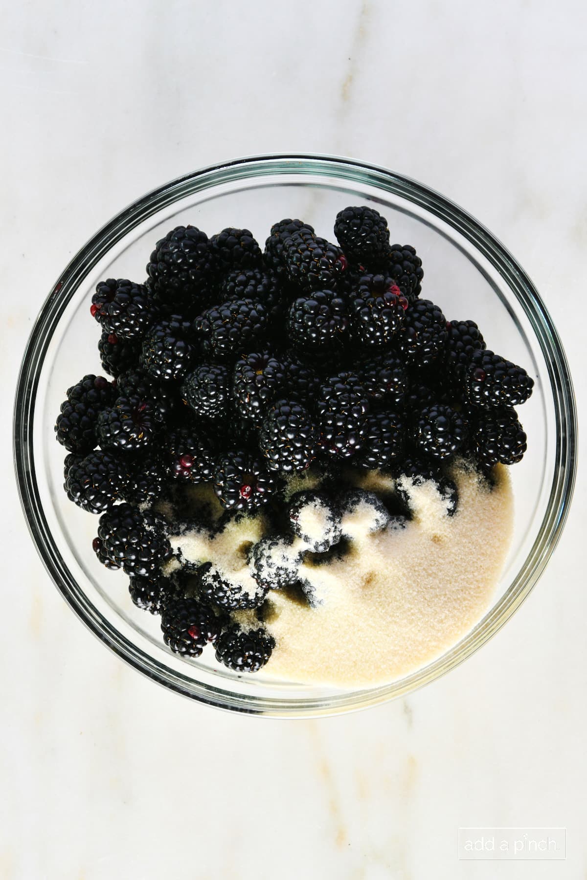 Blackberries and sugar in a glass bowl