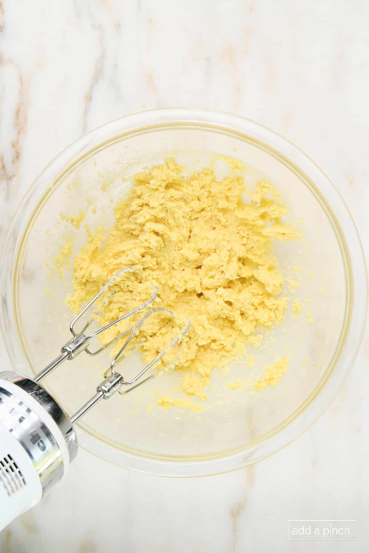 Butter and sugar mixed together in a glass mixing bowl