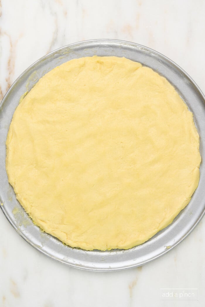 Sugar cookie dough pressed into a pizza pan