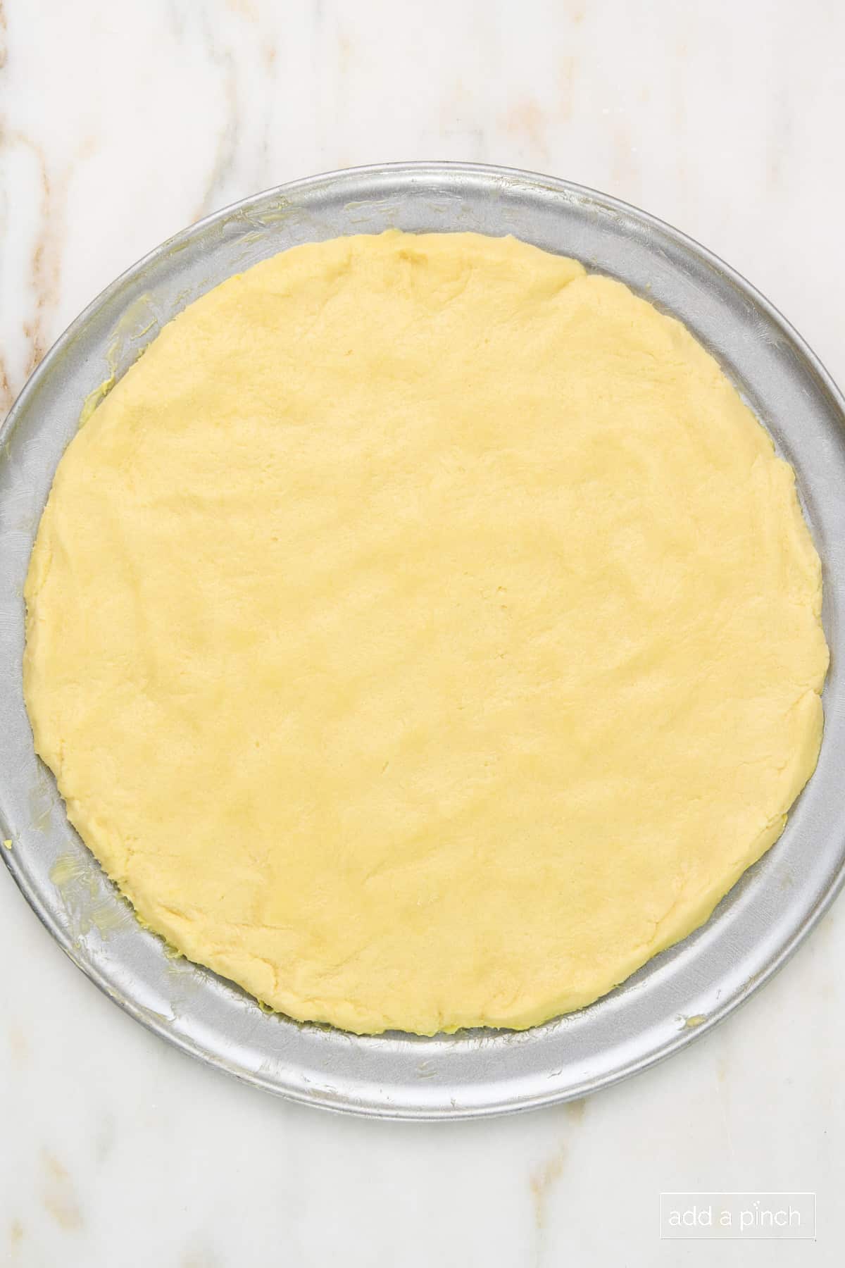 Sugar cookie dough pressed into a pizza pan