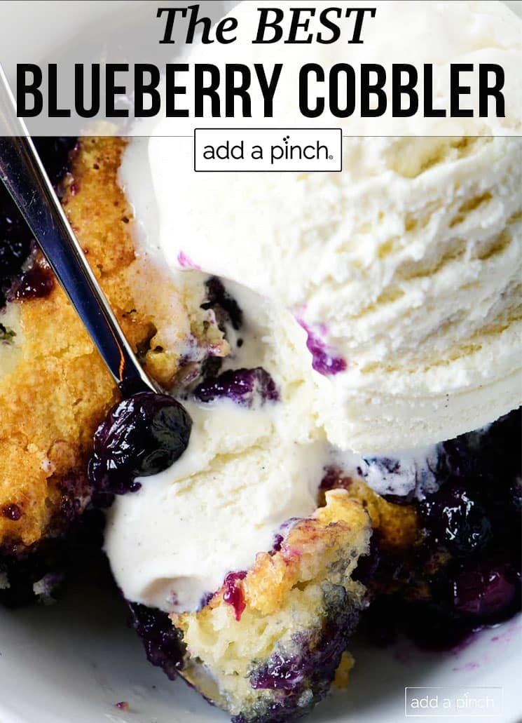 Bowl of blueberry cobbler with scoop of vanilla ice cream on top - with text - addapinch.com
