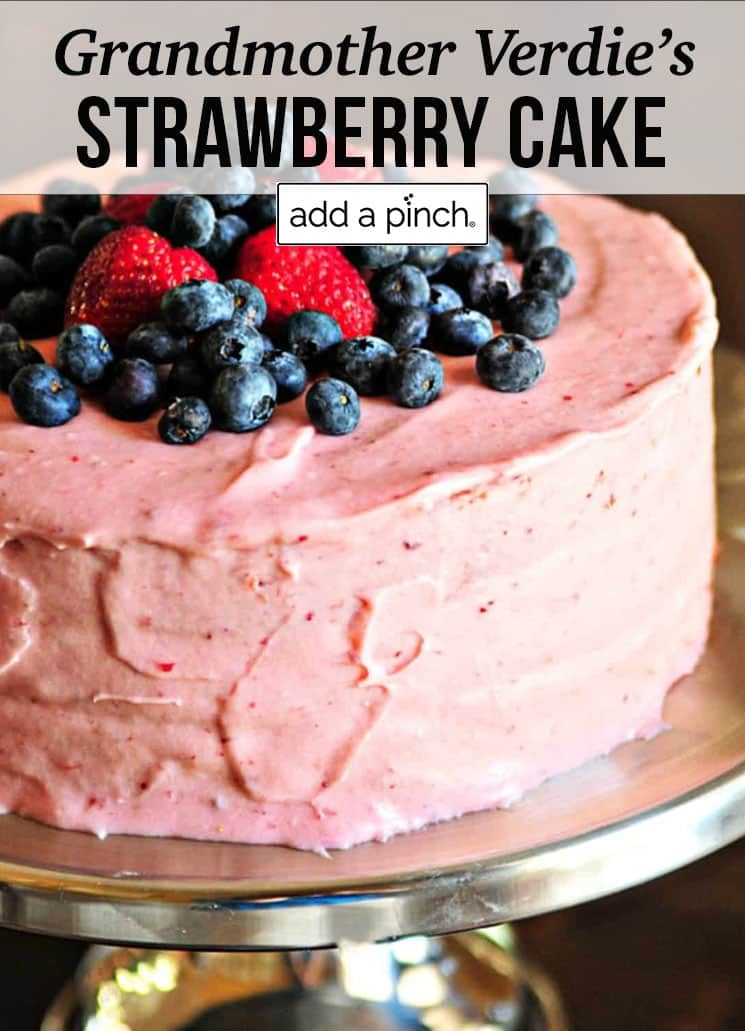 Strawberry cake with blueberries and strawberries on top - with text - addapinch.com