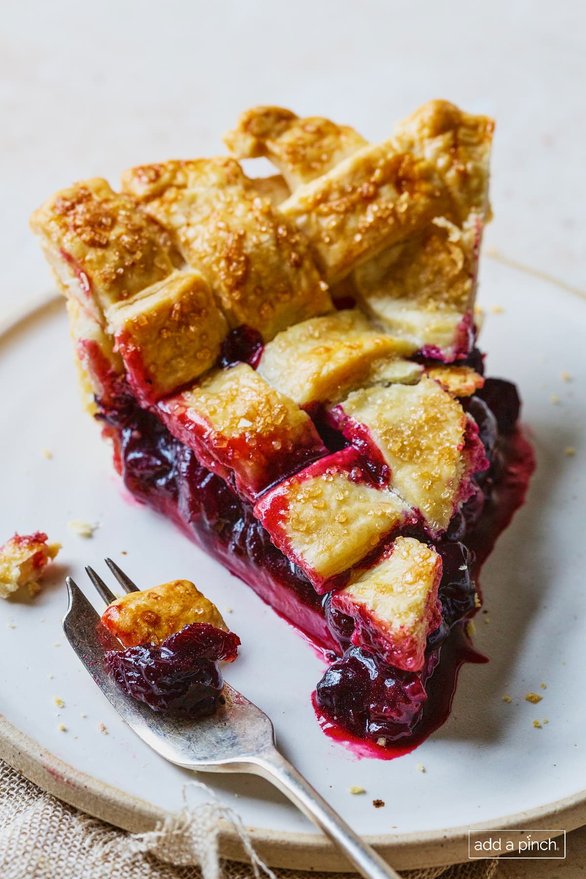 Slice of cherry pie with a lattice pie crust topping.