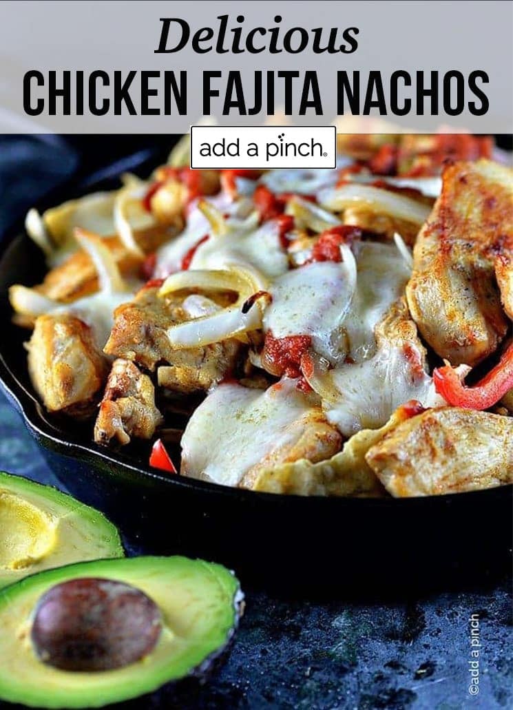 Skillet of chicken, peppers, onions and melted cheese surrounded by sliced avocado - with text - addapinch.com