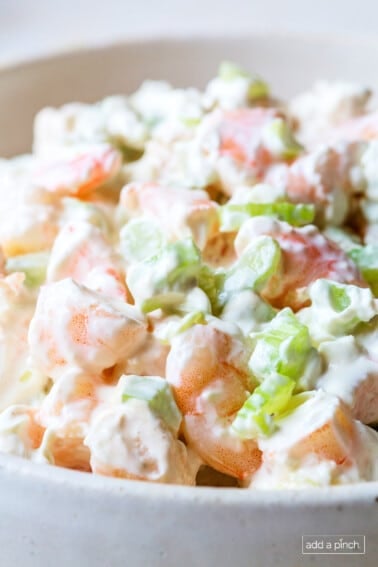 Closeup of shrimp appetizer with pink shrimp and chopped celery.