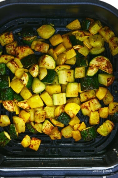 Photo of Air Fryer Squash with both yellow squash and zucchini inside the air fryer basket.