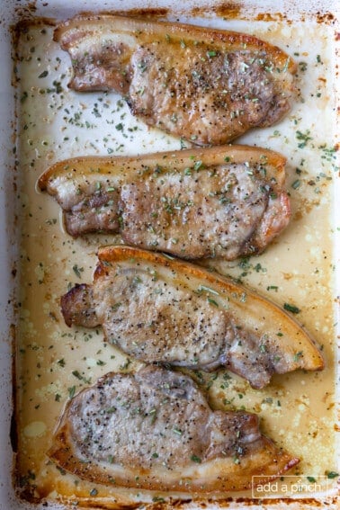Baked pork chops in a white baking dish