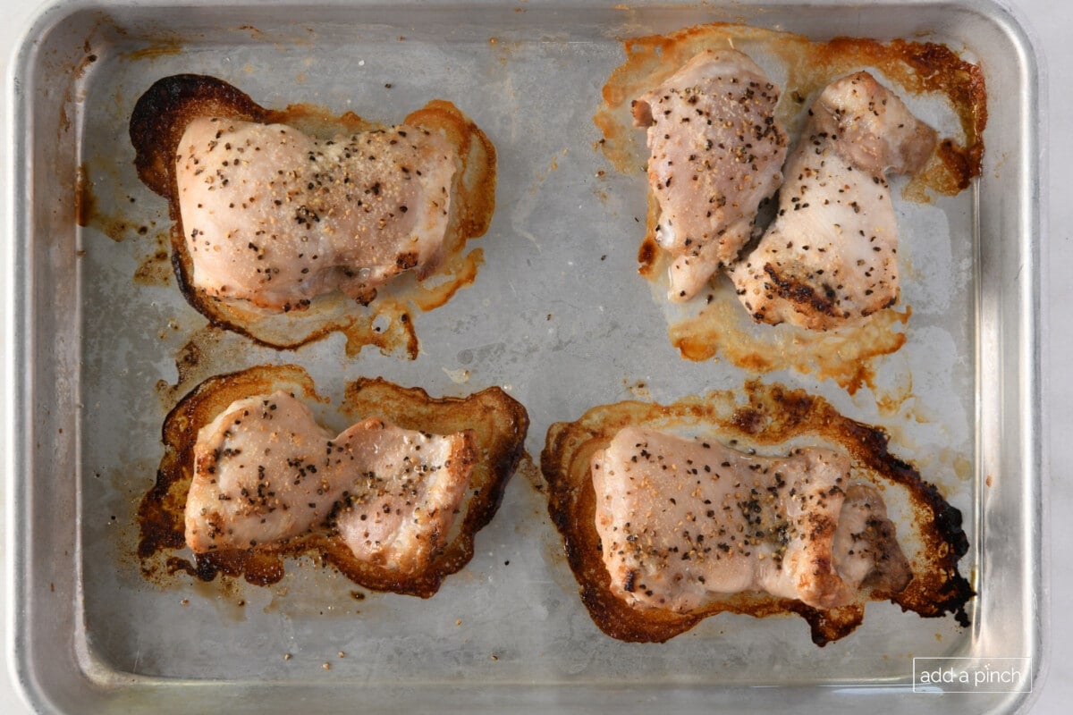 Photo of chicken thighs on a baking sheet.