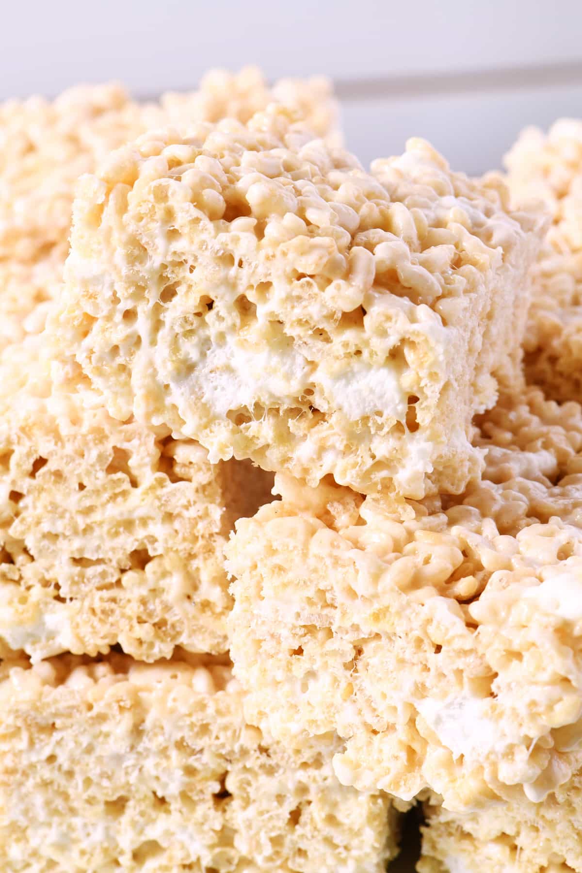 Stack of rice krispie treats on a white platter.