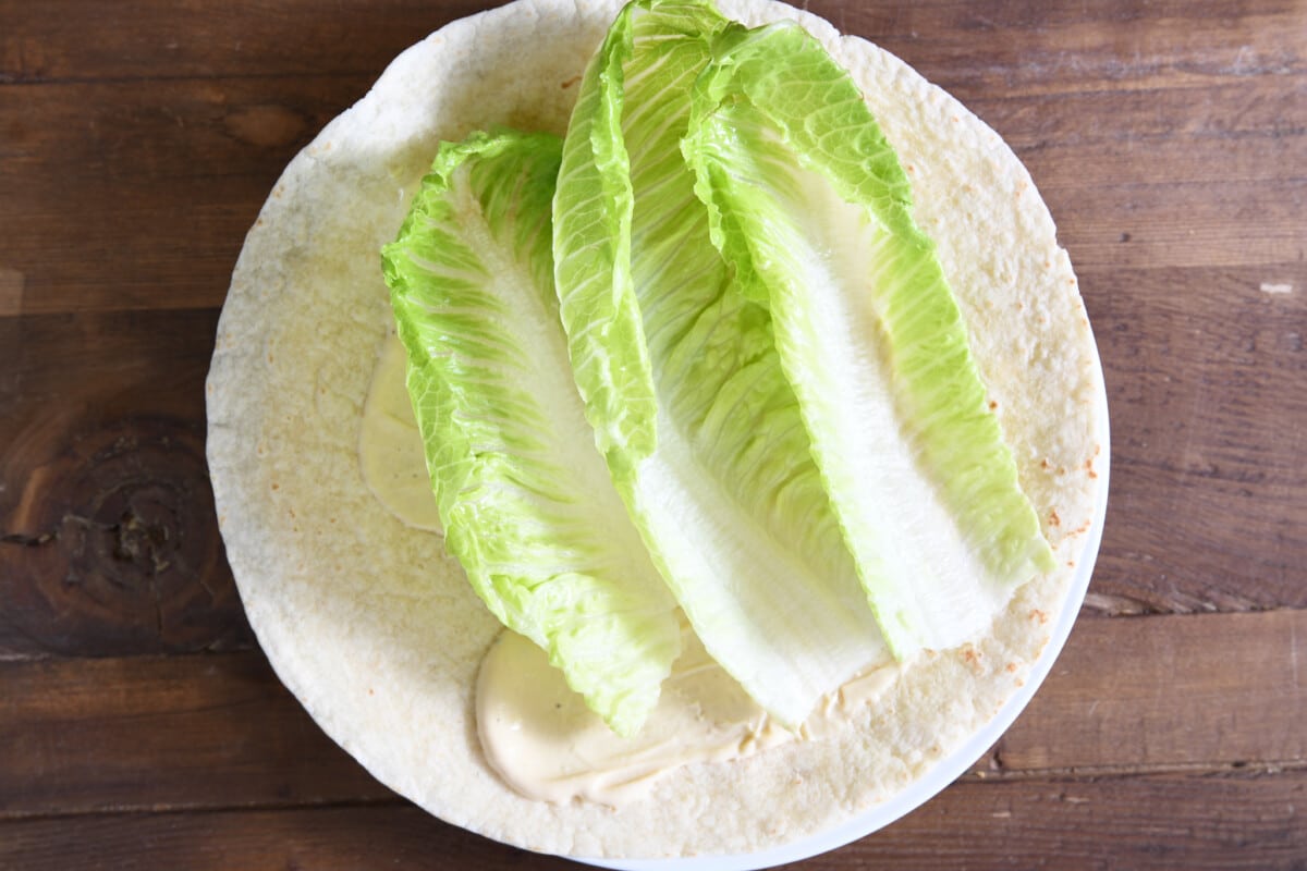Tortilla with caesar salad dressing and romaine leaves