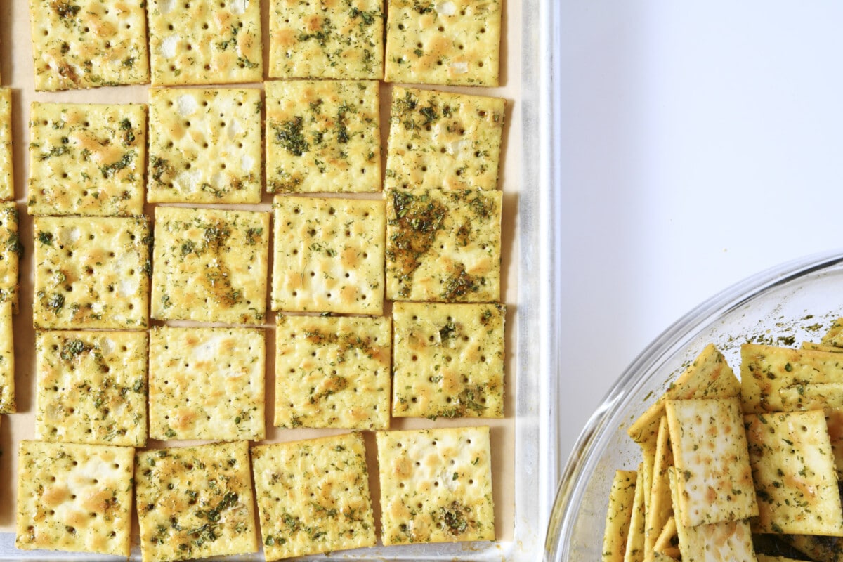 Coated saltine crackers on a sheet pan ready to bake.