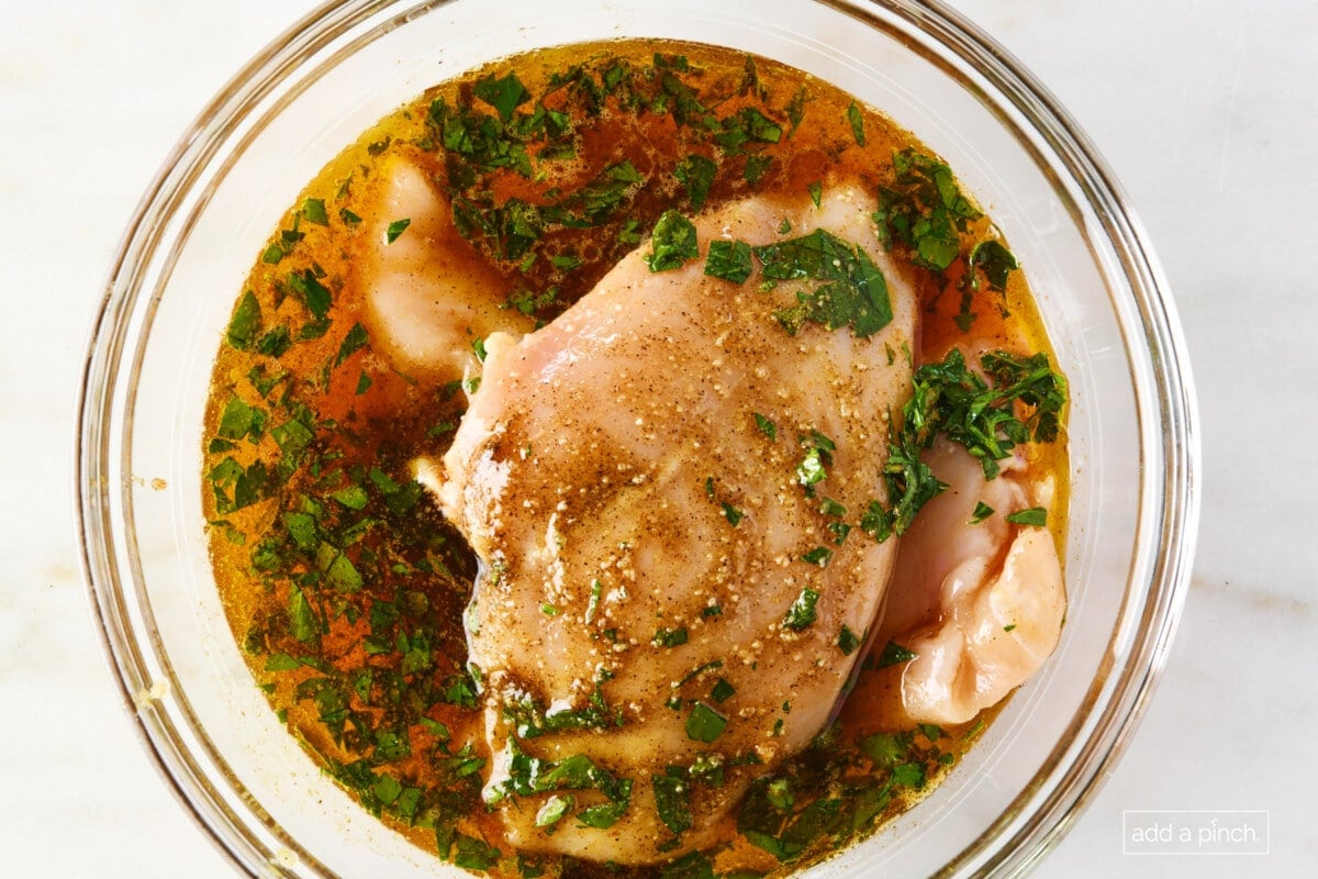 chicken in a glass bowl with marinade.