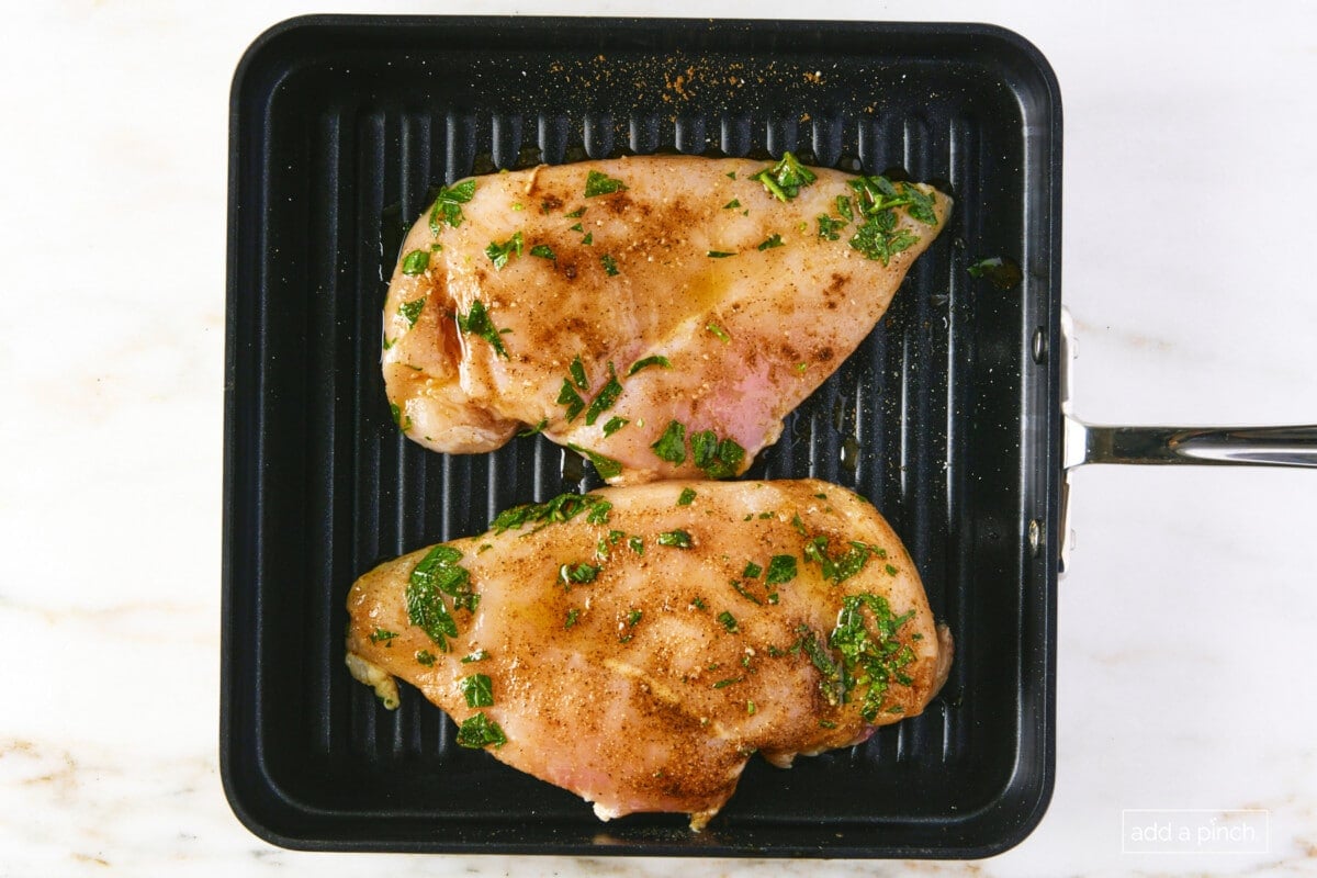 Chicken on a grill pan to be cooked.
