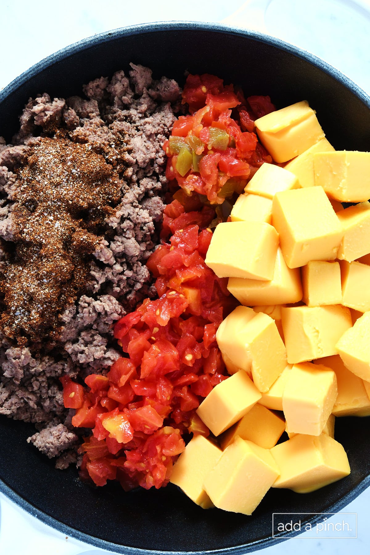 Ingredients for Rotel Dip in a skillet.