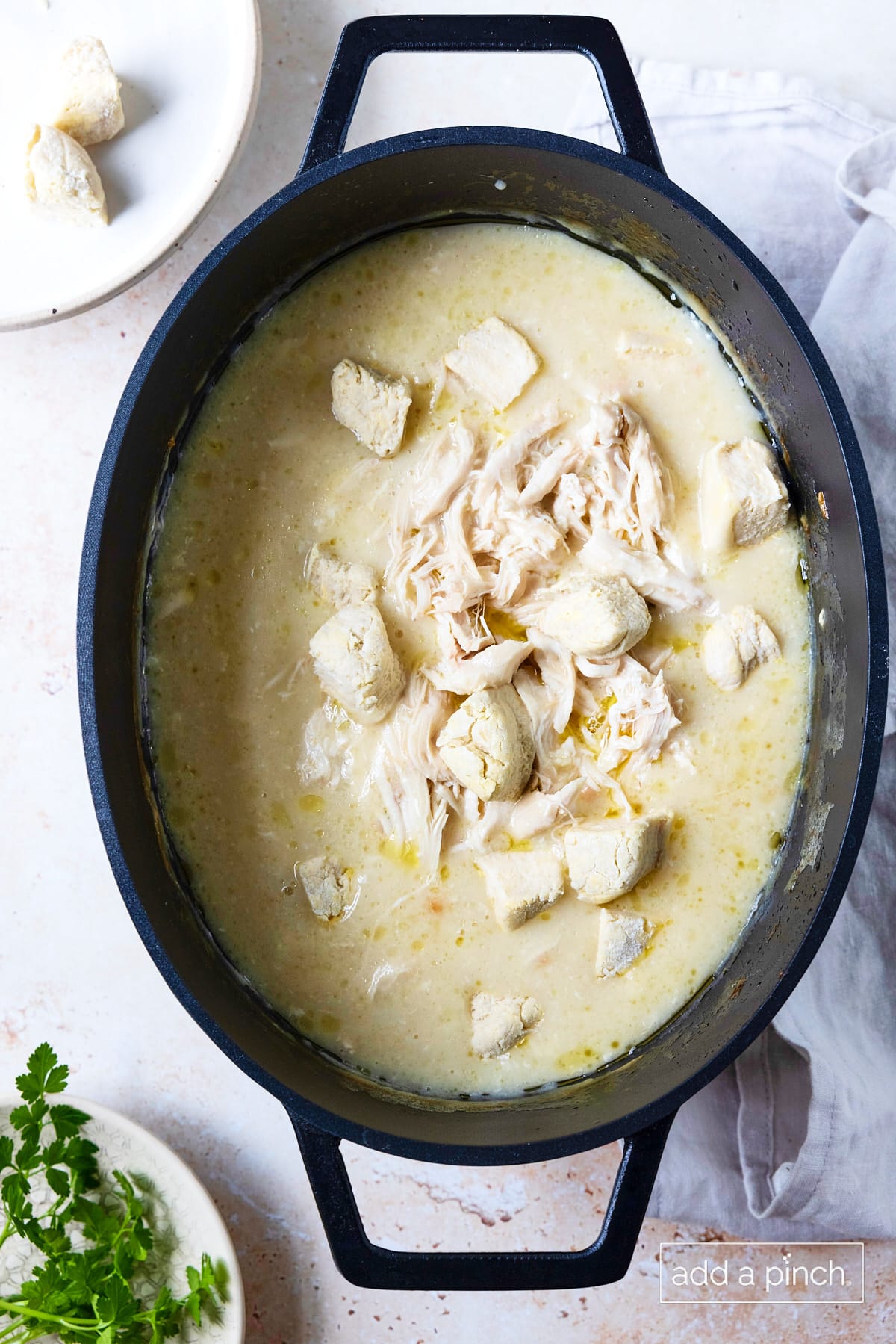 Shredded chicken and biscuit pieces added to slow cooker for chicken and dumplings.