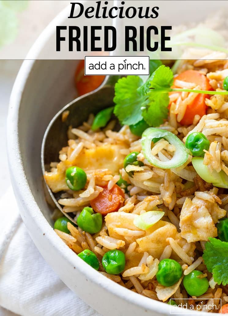 Fried rice with colorful vegetables in a white bowl - with text - addapinch.com