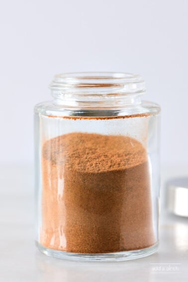 Closeup of glass spice container filled with apple pie spice.