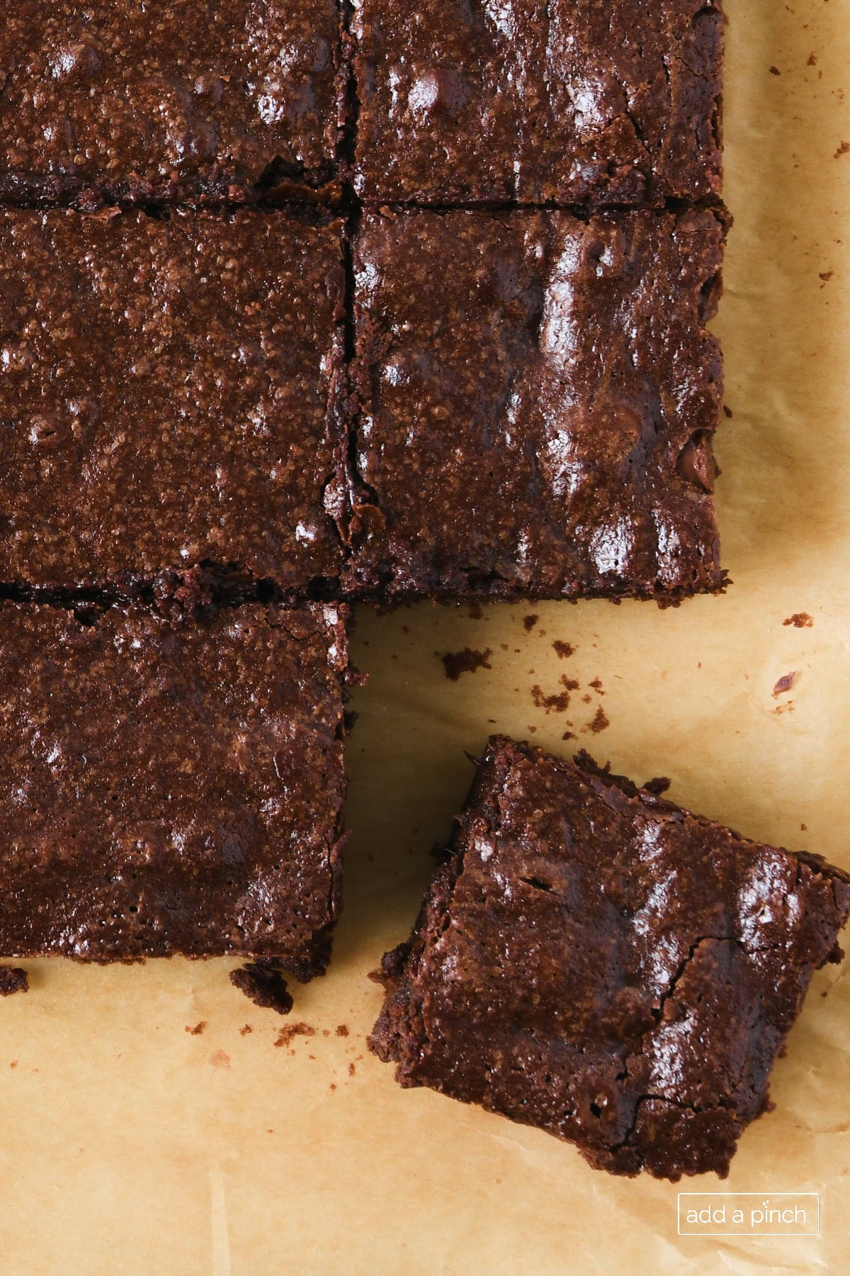 Photo of cut brownies on a piece of parchment paper.