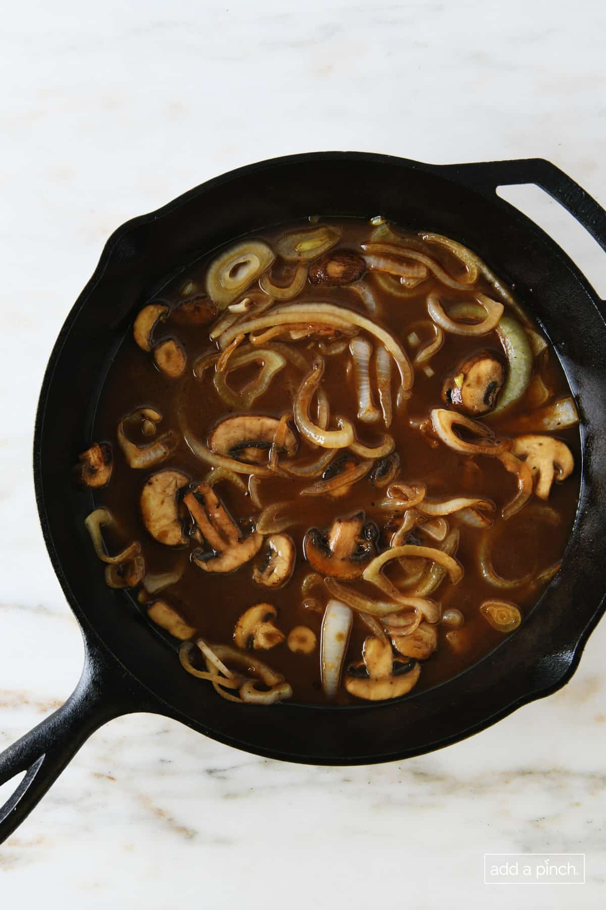 Mushroom and onion gravy in a black skillet.