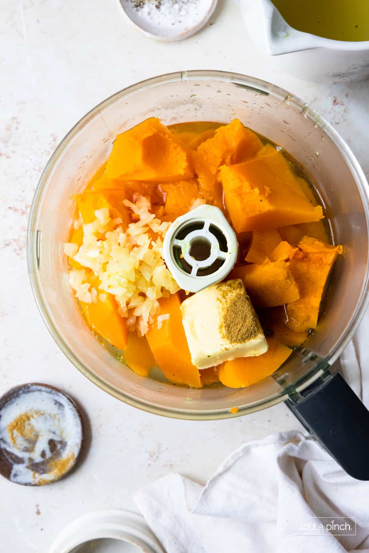 Food processor with roasted butternut squash, onions, butter, and cumin.