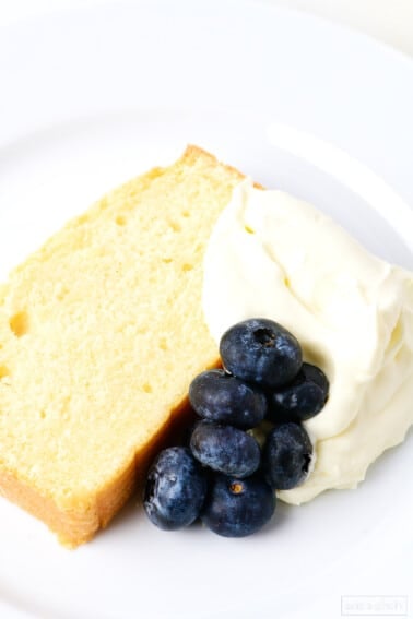 Slice of pound cake with whipped cream and blueberries.