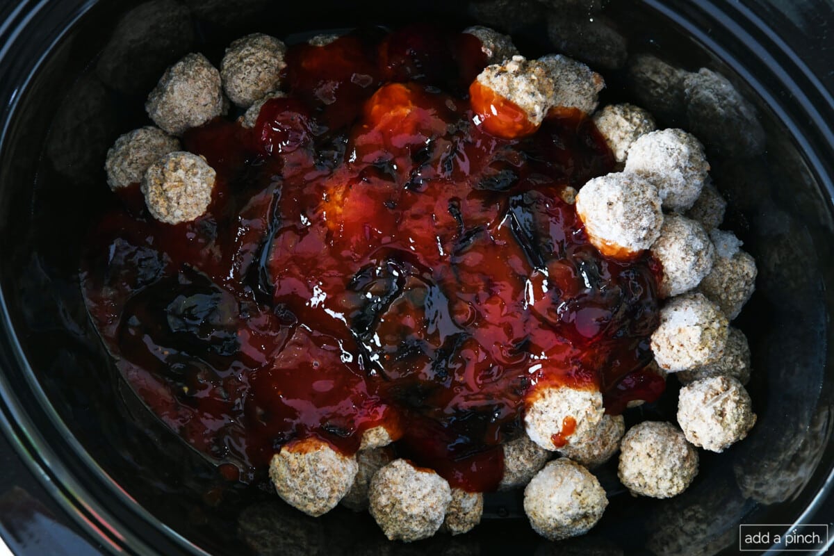 All ingredients for grape jelly meatballs in a slow cooker.