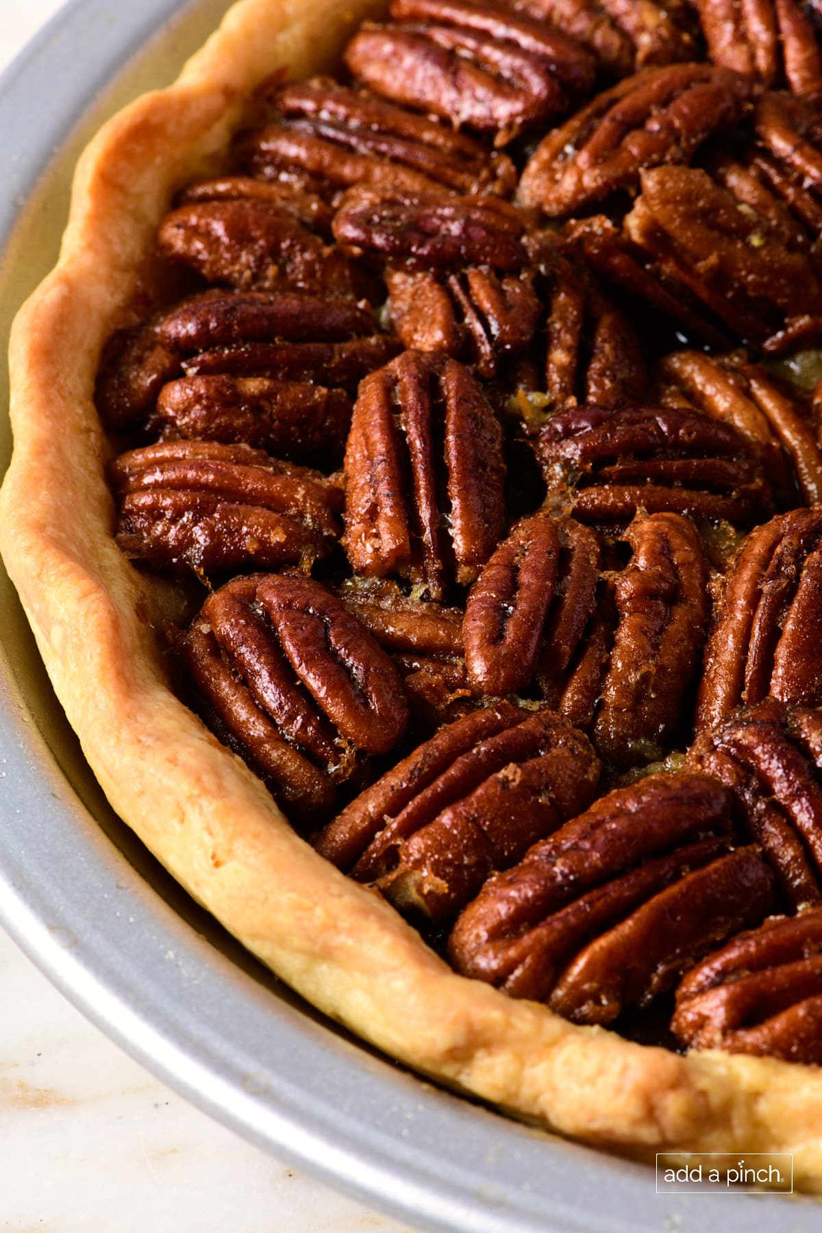Side view of toasty pecans in a freshly baked pie.