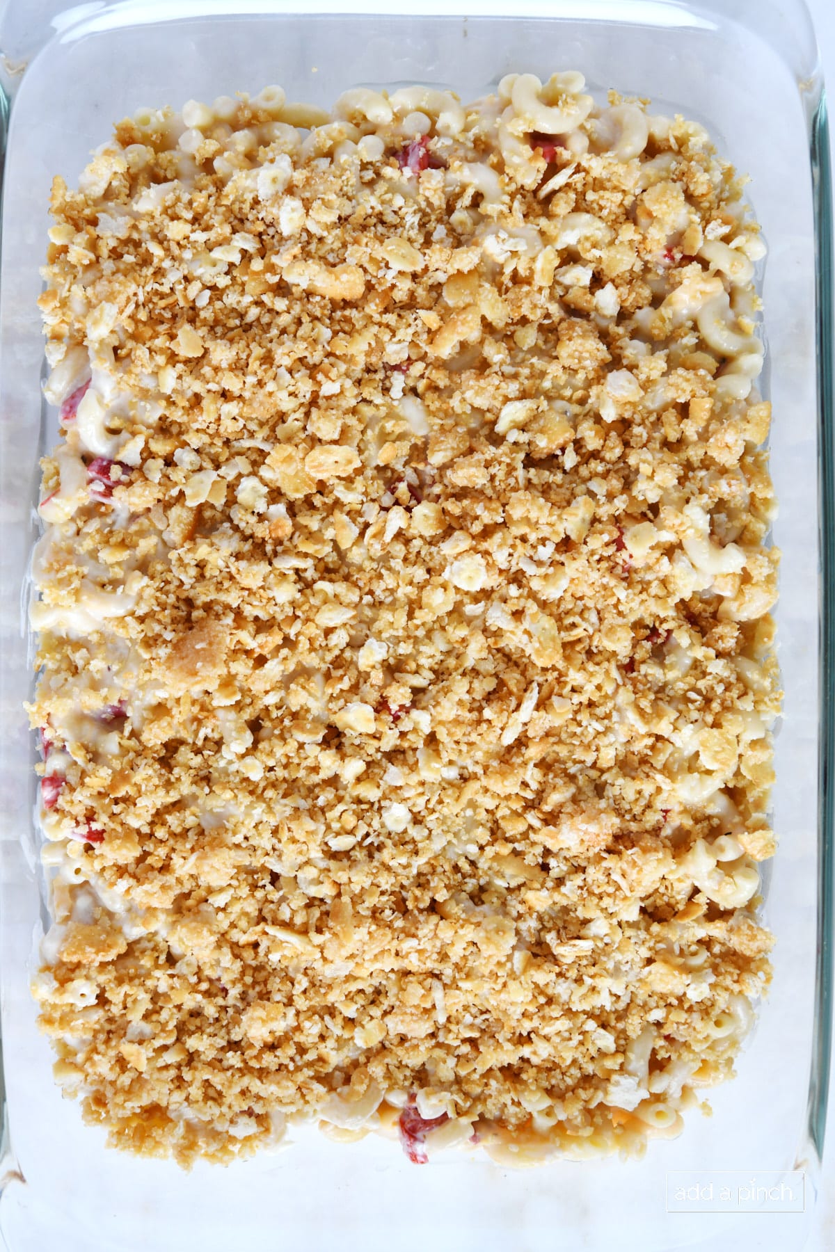 Southern Macaroni and Cheese ready topped with buttery cracker topping in a baking dish ready to place in oven for baking.