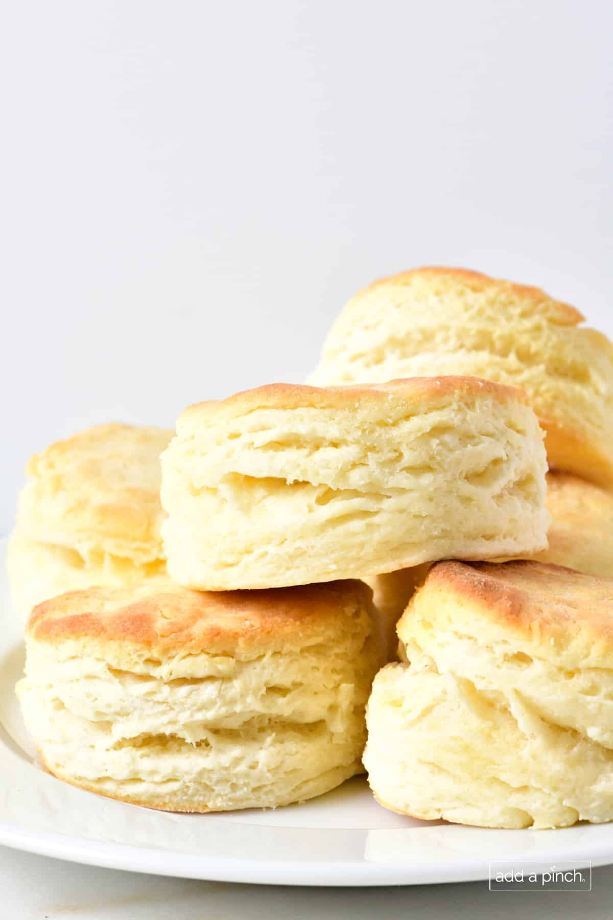 Stack of freshly baked three ingredient buttermilk biscuits on a plate. 