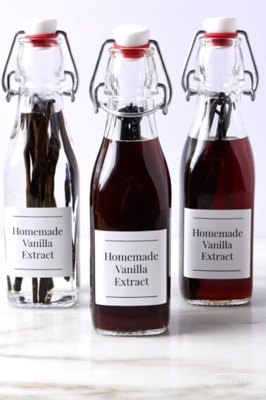 Homemade vanilla extract in different stages in swing top bottles.